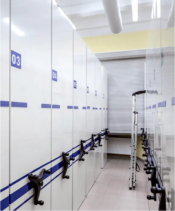 A series of white cabinets adorned with blue and white stripes, aligned in a straight line in a bright environment.